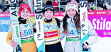 three skiers are posing for a picture with one wearing a hat that says ' gorenje ' on it