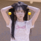 a girl wearing a white shirt with a pink bow