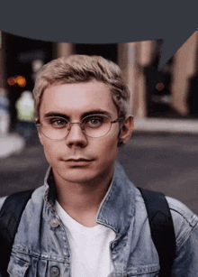a man wearing glasses and a denim jacket