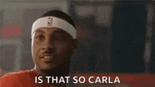 a basketball player wearing a headband and boxing gloves is talking to someone .