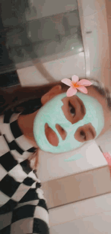 a girl is wearing a green mask on her face