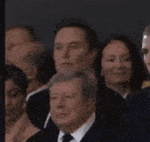a man in a suit and tie is standing in a crowd