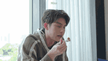 a man is eating a piece of food with a fork and the word mint is on the bottom
