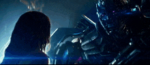 a woman is standing in front of a robot in a dark room .
