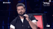 a man with a beard is sitting in front of a screen that says lavozkids1 on it