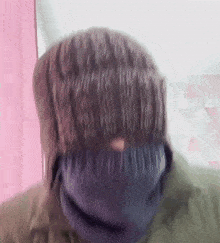a blurry picture of a person 's head with a blue scarf around their neck