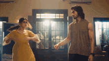 a man and a woman are dancing in a room in front of a window .