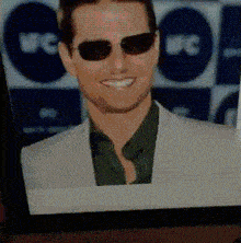 a close up of a man wearing sunglasses and a white jacket