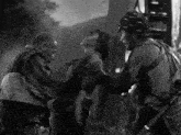 a black and white photo of a man holding another man 's neck