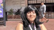 a woman wearing a lanyard that says ' jcpenney ' on it smiles for the camera