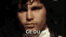 a close up of a man 's face with the words `` ge du '' written on his face .