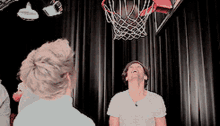 a man is looking up at a basketball hoop