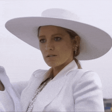 a woman wearing a white hat and white jacket