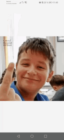 a young boy is smiling and giving the middle finger ..