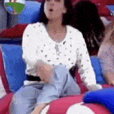 a woman is sitting on a pink and blue inflatable couch with her legs crossed .