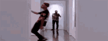 a man is dancing in a hallway while holding a microphone .