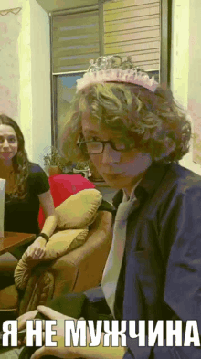 a man wearing glasses and a tiara says i 'm not a woman