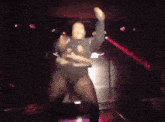 a man is dancing on stage in a dark room