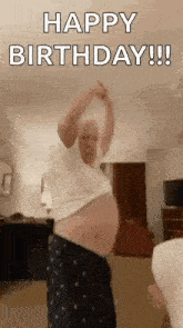 a man is dancing in a living room while wearing pajamas and a white shirt .