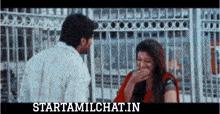 a man and woman are laughing in front of a fence and the website starttamilchat.in