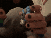 a person with black nails is holding a stuffed animal in their hands