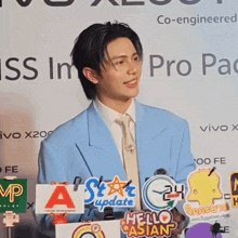a man in a blue suit and tie stands in front of a microphone