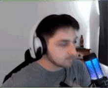 a man wearing headphones and a microphone is sitting in front of a microphone .