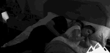 a black and white photo of a man and woman sleeping in bed .