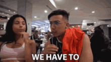 a man and a woman are sitting at a table with the words we have to written in front of them