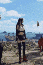 a woman is standing in front of a body of water with a man flying in the background .