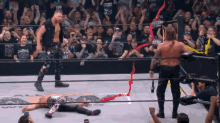 wrestlers in a ring with one wearing a shirt that says ' aew '