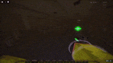 a person is playing a video game in a dark room with a green box in the middle of the screen .