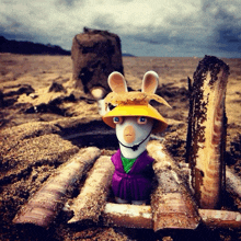 a toy rabbit wearing a yellow hat and purple dress