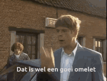a man in a suit stands in front of a brick building with the words dat is wel een goei omelet written on the screen