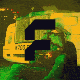 a man is smoking a cigarette in front of a car with a license plate that says m700f