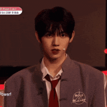 a young man wearing a jacket and tie with the word planet on the front