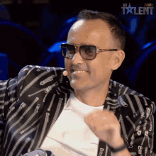 a man wearing sunglasses and a jacket with zippers on it