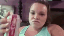 a woman is holding a can of soda and making a face