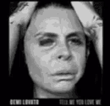 a black and white photo of a woman 's face with her hands on her head