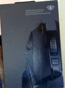 a person is holding a black box that says wireless gaming mouse