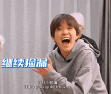 a man with his mouth open and a blue sign that says thi-o picks up the leftovers behind him