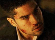 a close up of a man 's face with a bloody nose