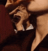a close up of a person drinking from a bottle while sitting in a chair .
