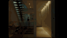 a man in a suit is standing in a hallway next to a staircase