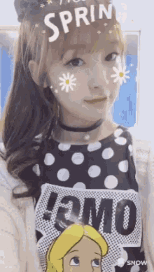 a girl wearing a black and white polka dot shirt with the word spring on it