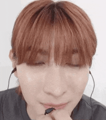 a close up of a person wearing headphones and making a face .