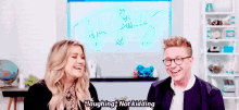 a man and a woman are laughing together in a room .