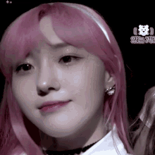 a close up of a woman 's face with pink hair and earrings