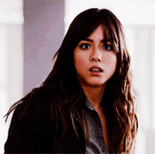 a close up of a woman 's face with a shocked look on her face