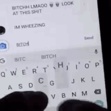 a person is typing on a cell phone with a shadow on the keyboard .